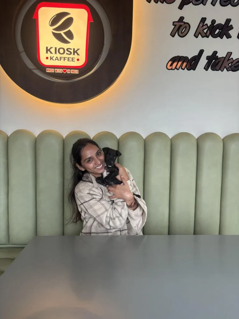 Rio, a small black puppy with a white chest patch, being held by his owner indoors before he went missing in Kolhapur